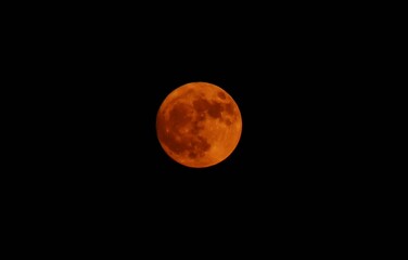 Surface of big red full moon on the dark sky background