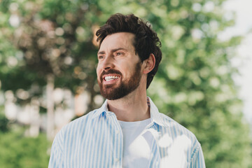 Young man with stylish look enjoys outdoor cityscape under sunlight on a spring afternoon
