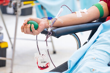 Close-up of a person donating blood in a medical clinic. A healthcare concept symbolizing altruism,...