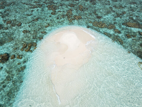 Aerial view of a pristine, sun-kissed sandbank surrounded by the turquoise embrace of the ocean's gentle waves, Thoddoo, Alif Alif Atoll, Maldives.
