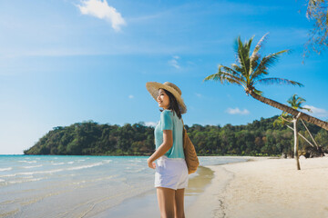 Happy traveler asian woman with hat relax on Klong chao beach at day in Koh Kood Trat Thailand Summer travel holiday vacation concept