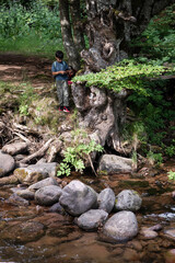 Children exploring nature by the river bank using mobile phone