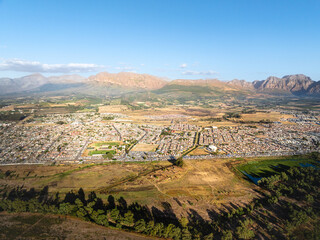 Eine weite Luftaufnahme der Winelands mit Stadtgebieten, Flüssen, Seen und Bergen unter klarem...