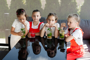 Group of children enjoying refreshing drinks at a cozy outdoor seating area