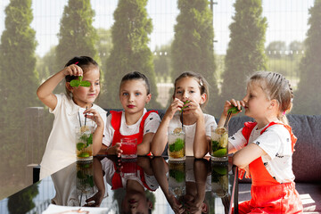 Group of happy children enjoying fresh drinks in a garden setting