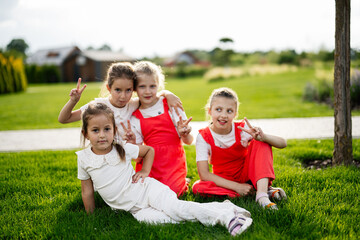Fototapeta premium Group of young girls sitting on grass in a sunny park setting