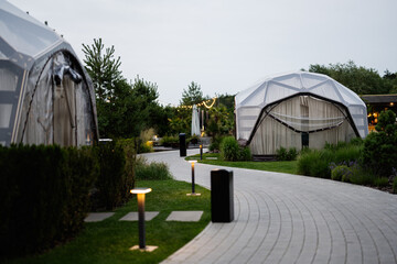 Outdoor glamping domes at a modern resort with elegant lighting and pathways