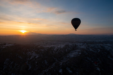 Landscape view at sunrise with hot air balloons in silhouette