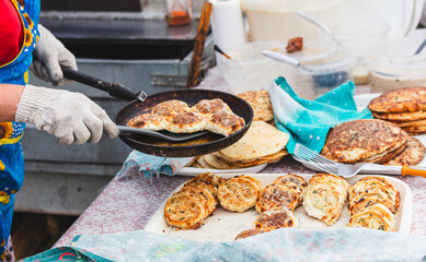 A woman is cooking food on a pan