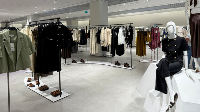 Fashion retail store interior showcasing modern clothing displays and stylish mannequins in a spacious layout