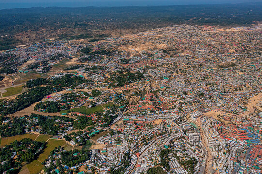 Aerial view of a sprawling landscape where dense settlements meet lush greenery, creating a textured tapestry of human habitation, Balukhali Bazar, Chittagong Division, Bangladesh.