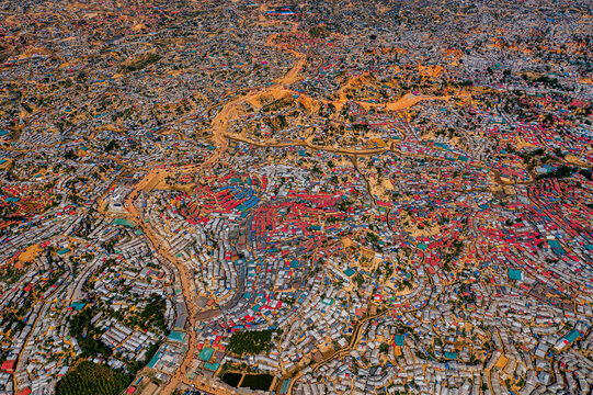 Aerial view of sprawling settlements with tightly packed structures and pathways, a tapestry of human habitation stretching across the landscape, Balukhali Bazar, Chittagong Division, Bangladesh.