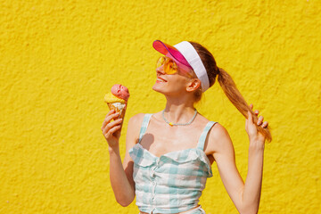 Happy Young Woman with Ice Cream Cone on Bright Yellow Wall Enjoying Sunny Summer Day