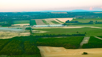 Obraz premium Scenic aerial view of rural landscape with golden fields at warm sunset light