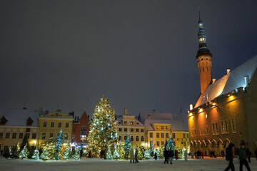 Christmas tree and decoration background with a church and snow on late winter evening in Tallinn,...