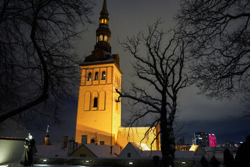 Illuminated Church tower in Tallinn old Town on dark and cold winter snow evening, Estonia