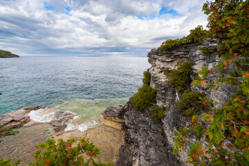 Rugged Rocky Limestone Cliff Surrounded by Turquoise Water of Lake Huron