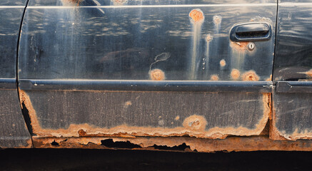 Damaged rusted car texture with peeling paint and corroded metal surface