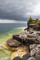 Rugged Rocky Limestone Cliff Surrounded by Turquoise Water of Lake Huron