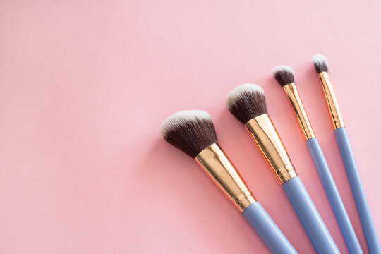 makeup brushes on pink background