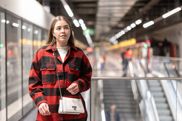 Young woman makes a transfer between metro stations and goes to the train. Girl waiting for a train...