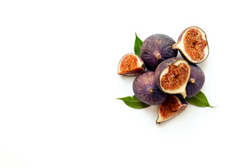 Purple ripe figs fruit and slices with green leaves top view on a white background