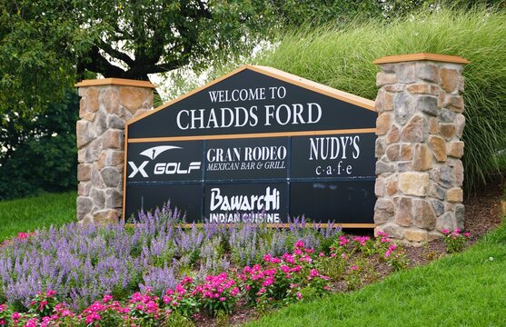 Chester County, Pennsylvania, U.S - July 22, 2025 - A welcoming sign into Chadds Ford, featuring X Golf, Gran Rodeo, Nudy's Cafe and Bawarchi Indian Cuisine