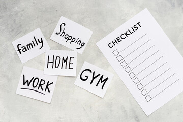 Checklist and many paper cards with hand drawing of different life activities, top view. Life balance and planning concept.