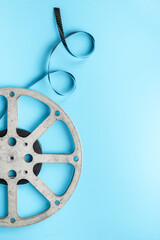 Old 35mm motion picture film reel on blue background. Cinema concept