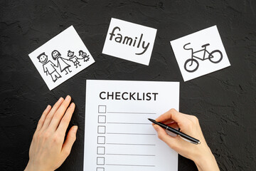 Hand writes in Checklist and many paper cards with hand drawing of different life activities, top view. Life balance and planning concept.