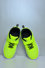 Light green sneakers on a gray background.