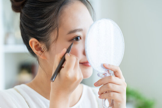 アイライナーを使う若い女性