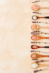 Spa treatment body care cosmetics - sea salt and scrubs in spoons, top view