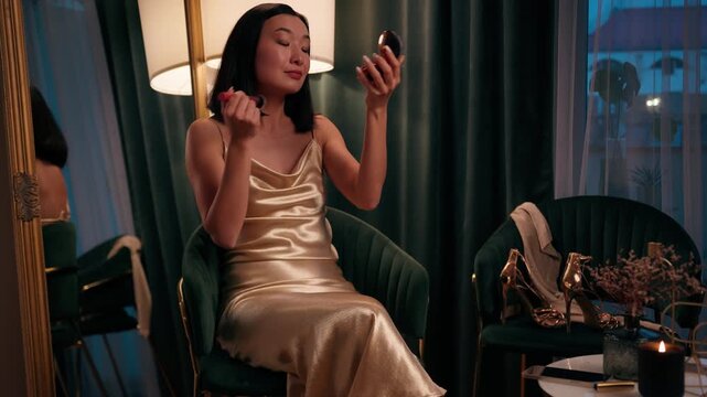 Asian woman Chinese Japanese female Korean doing make-up applying powder bronzer contouring skin care holding mirror receive mobile phone message online excited happy carefree smiling at home evening