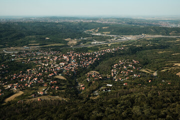Aerial view of houses and winding roads in a suburban village near Belgrade, Serbia, seen from Avala Tower.