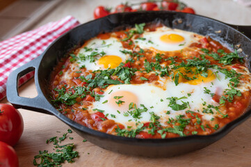 Homemade baked beans with fried eggs, sunny side up in a frying pan.