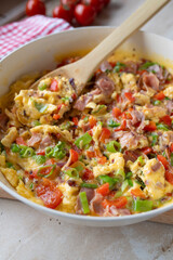 Scrambled eggs with ham and vegetables. Healthy quick breakfast, dinner or luch fresh and homemade cooked