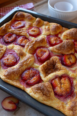 Oven pancake with plums on a baking tray fresh and homemade baked