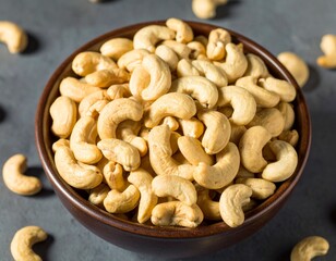 Fototapeta premium Close-up of cashews, showcasing their unique shape and inviting color ideal for themes of healthy snacks, vegan recipes, or wholesome ingredients. A collection of cashews, ready to be enjoyed 
