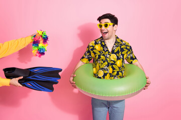Young Man in Tropical Shirt Holding Inflatable Ring Receiving Beach Accessories on a Vibrant Pink...
