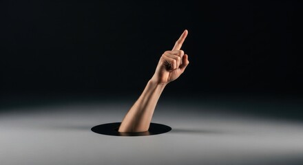 A Human Hand Emerges From a Hole Pointing Upwards