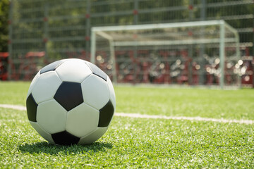Soccer ball on green grass field before football gate. Soccer ball on field in front of goal post....