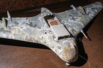 Single-seat jet aircraft, Russian drone, gray-white camouflage, sealed canopy, metal plate on nose, wooden floor, overhead lighting, streamlined body, angled position, balanced composition, isolated