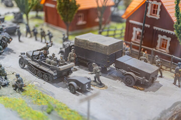 Miniature war scene WWII military truck, soldiers in camouflage uniforms, helmets goggles, quaint...