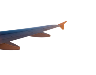 Airplane wing view from plane window over foggy mountains at sunset. Sky and sun abov .