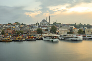 Suleymaniye mosque dominating istanbul skyline at sunset with ferryboats navigating golden horn