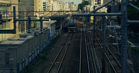 Naklejka premium View from the bridge to the railway in the city. The train is moving along the rails, accelerated video