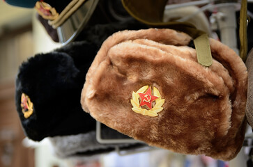 Ushanka hats with soviet badges hanging in a souvenir shop