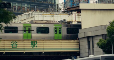 A train rides over a railway bridge in Tokyo, view from below