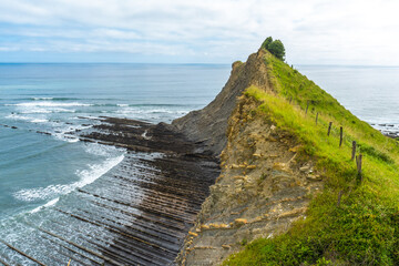 Flysch cliffs rising from the ocean at sakoneta beach, zumaia, basque country